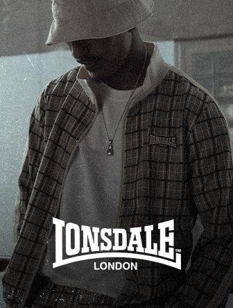 A person wearing a plaid jacket and bucket hat, with a Lonsdale London logo overlay.