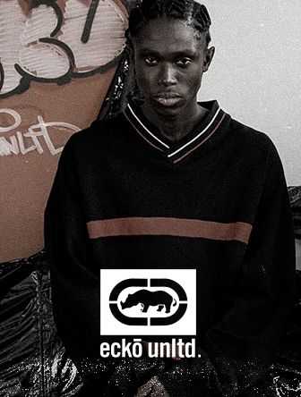 Person wearing a dark Ecko Unltd. sweater stands in front of graffiti art.