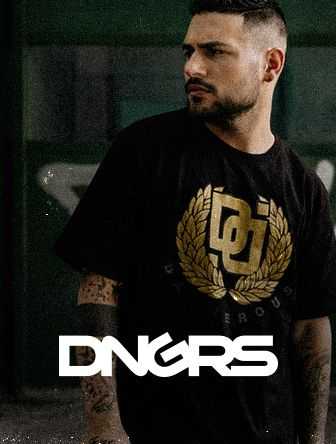 Man wearing a black DNGRS shirt with a gold emblem, standing in front of a dark green background.