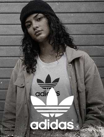 Person in a beanie and jacket over an Adidas t-shirt stands against a striped background, with a vintage photo effect.