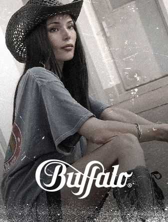 Woman in a cowboy hat and oversized t-shirt sitting, with "Buffalo" logo overlay. Vintage style with a soft focus effect.