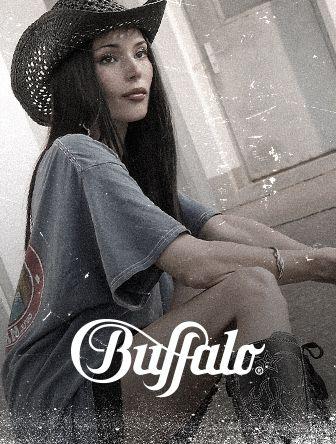 Woman in a cowboy hat and oversized t-shirt sitting, with "Buffalo" logo overlay. Vintage style with a soft focus effect.