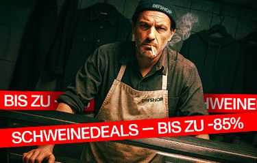 Man in an apron smoking, with red banners displaying German text about deals up to 85% off. Dimly lit background with hanging clothes.