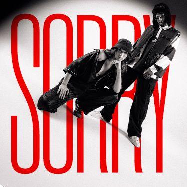 Das Bild zeigt zwei Models in sportlicher Streetwear vor dem großen roten Schriftzug "SORRY" auf weißem Hintergrund. Der Stil ist modern und minimalistisch gehalten.