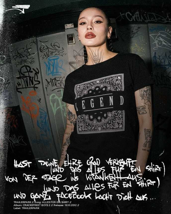 Person with tattoos in a "Legend" T-shirt stands against a graffiti-covered wall, with bold text overlay.
