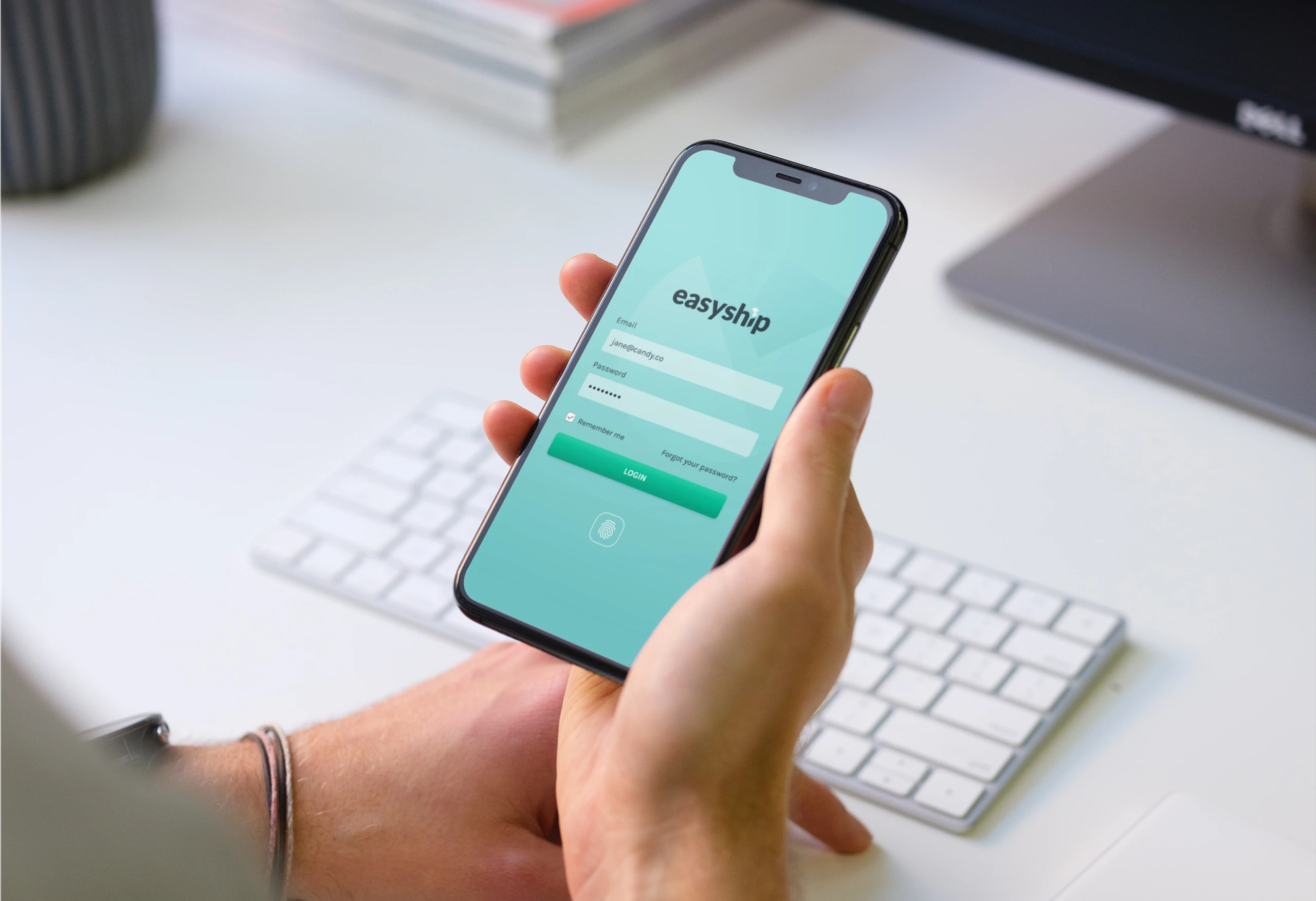 Picture of person holding smartphone, visible on the screen is the login view from the Easyship mobile app.