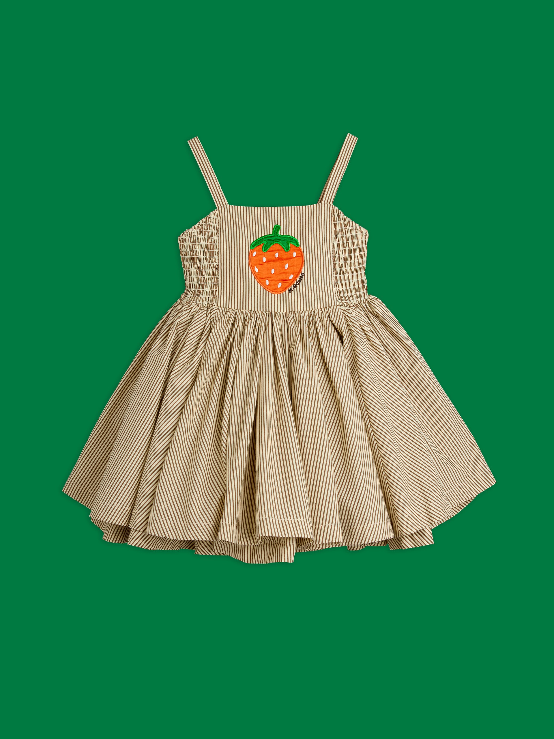 Striped children's dress with spaghetti straps, featuring an embroidered strawberry on the front, set against a green background. Dress from Mini Rodini Table Tennis collection.