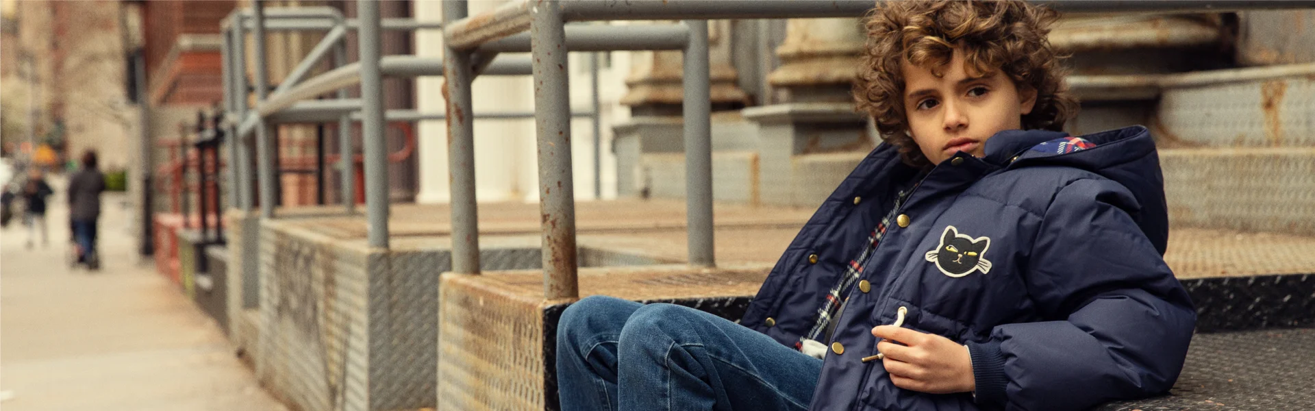 Boy in kids jacket with sew on patches from Mini Rodini. Discover more kids clothing such as kids coats at Mini Rodini