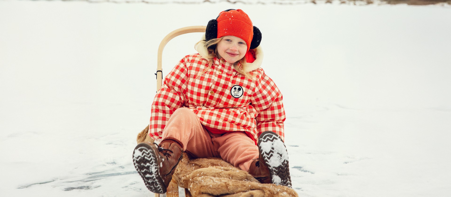 Girl wearing Ritzratz patch gingham heavy puffer from Mini Rodini