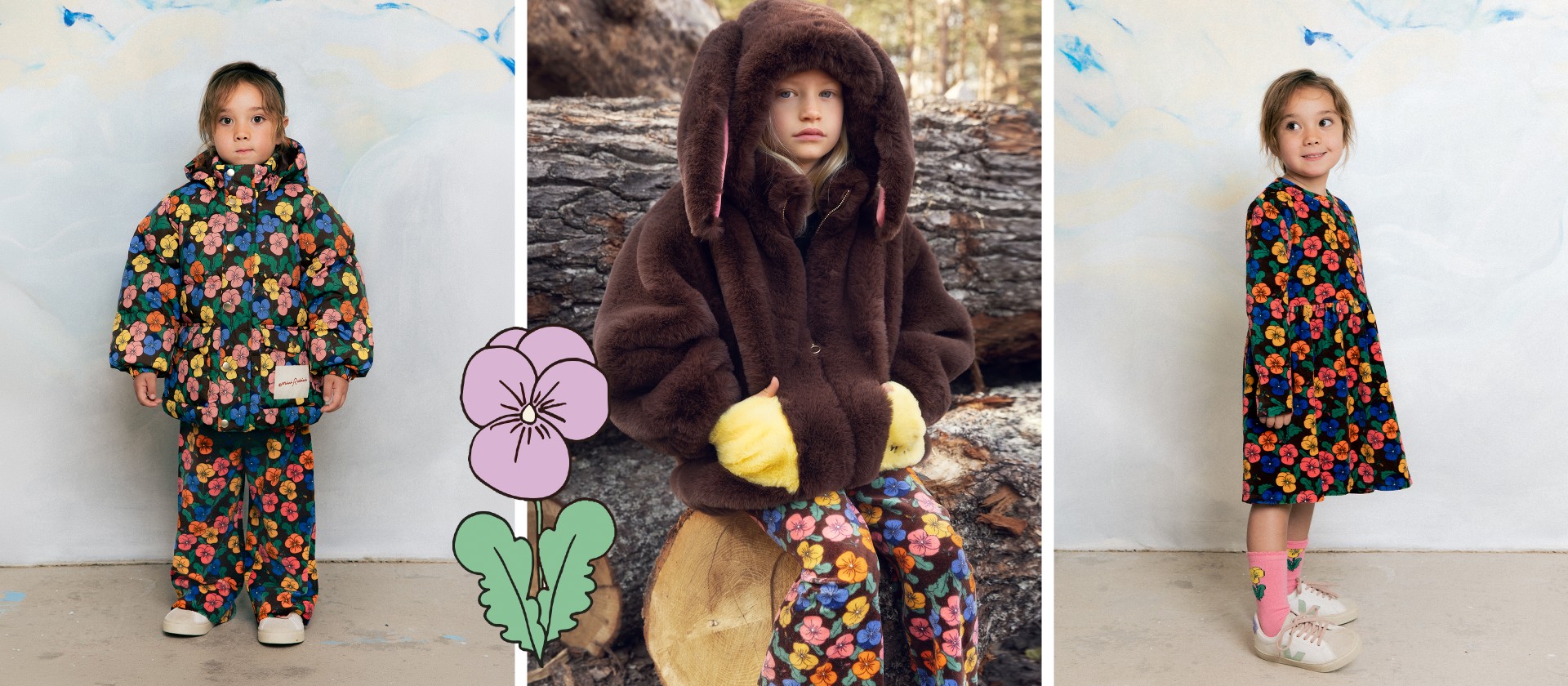 Child in a furry brown coat with bunny ears, sitting on a log, wearing floral pants and yellow mittens, with a drawn flower beside them.