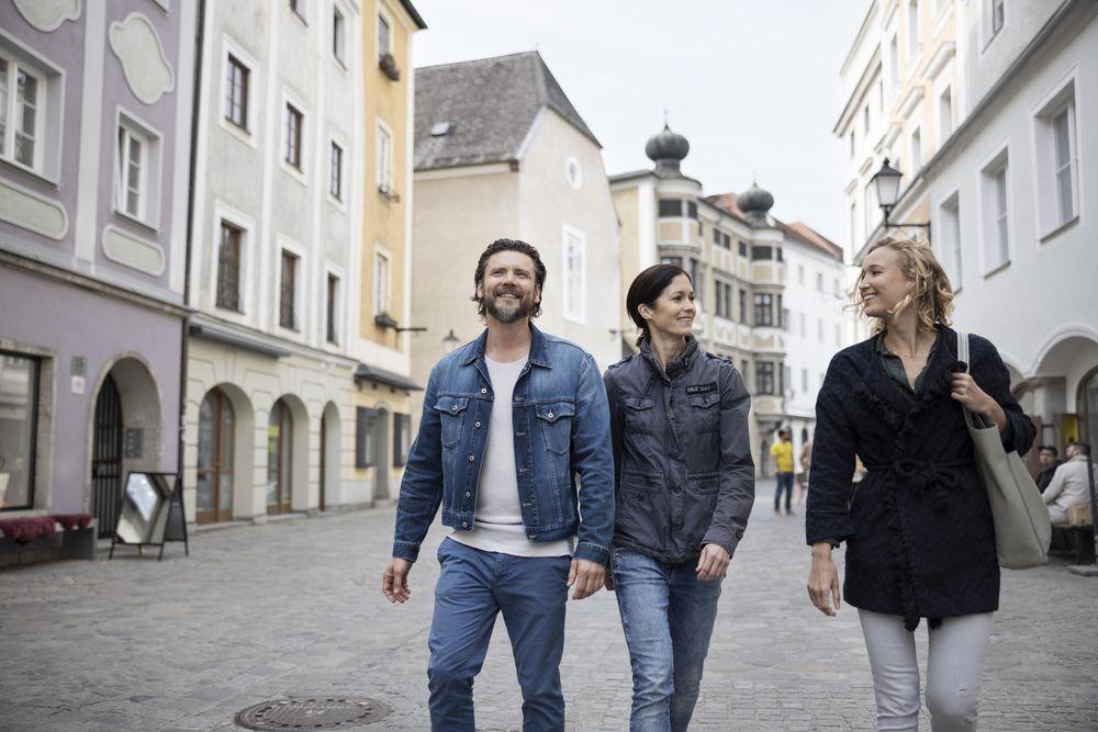 Drei Personen laufen durch die Linzer Altstadt.