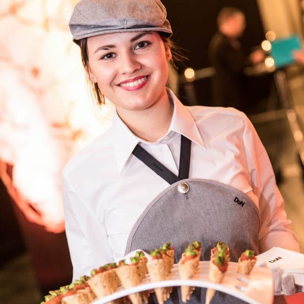 Eine Frau welche kleine Speisen anbietet