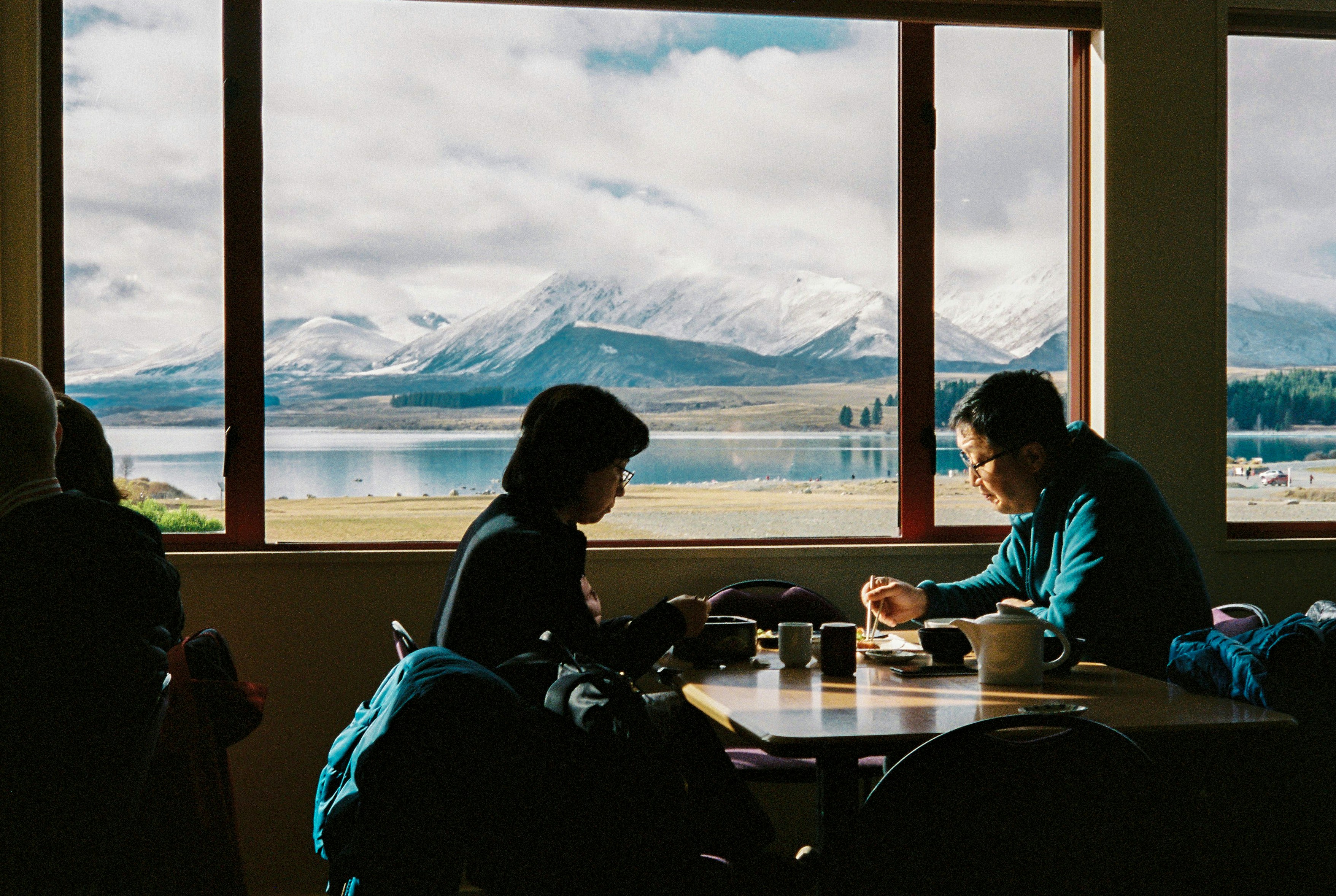 Couple eating dinner at a table with a snowy mountain view