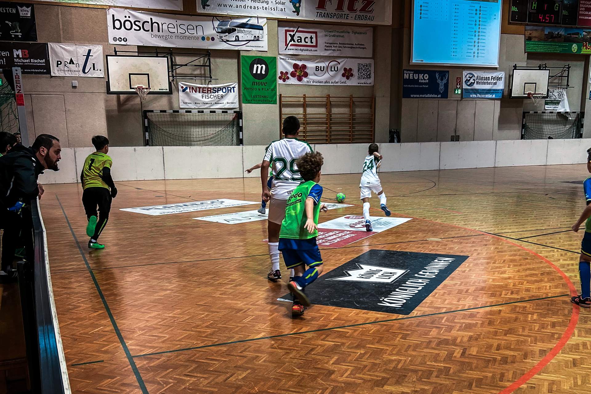 Kinder spielen in der Halle Fußball