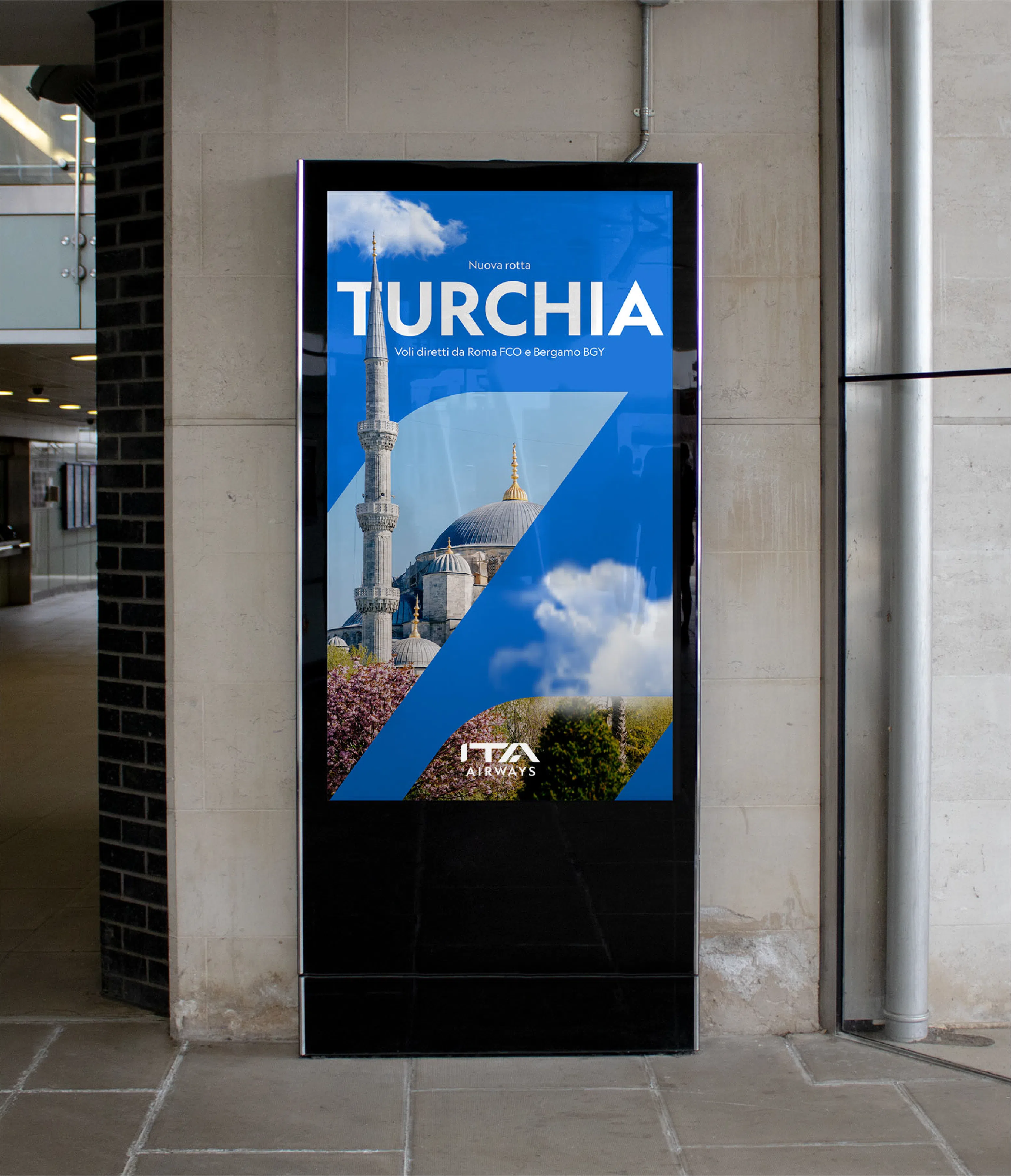 ITA Airways advertising on a digital screen inside an airport