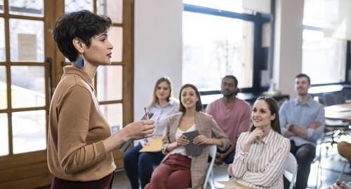 A woman addressing a room of students
