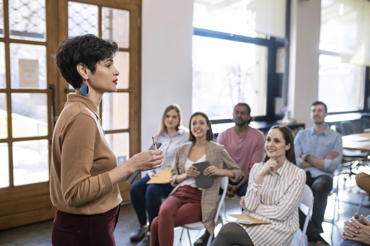 A woman addressing a room of students