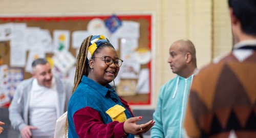 A women speaking to a man in a community centre