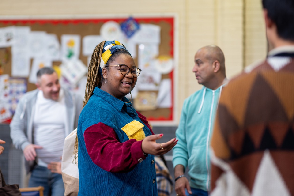 A women speaking to a man in a community centre