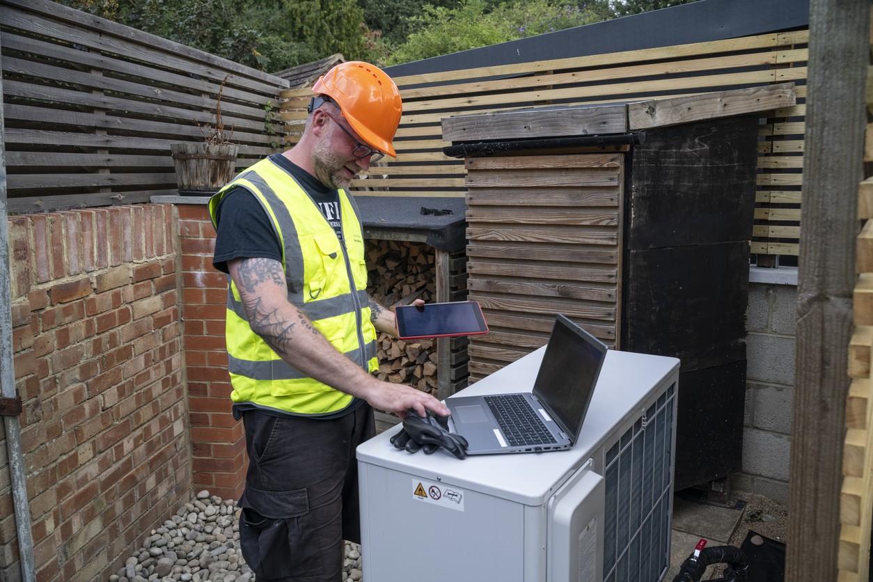 Man checking an air source heat pump helping to build green careers in Wales