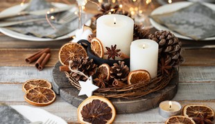 A festive centrepiece of candles sat among pine cones, dried orange cuttings and star anise on a round tray