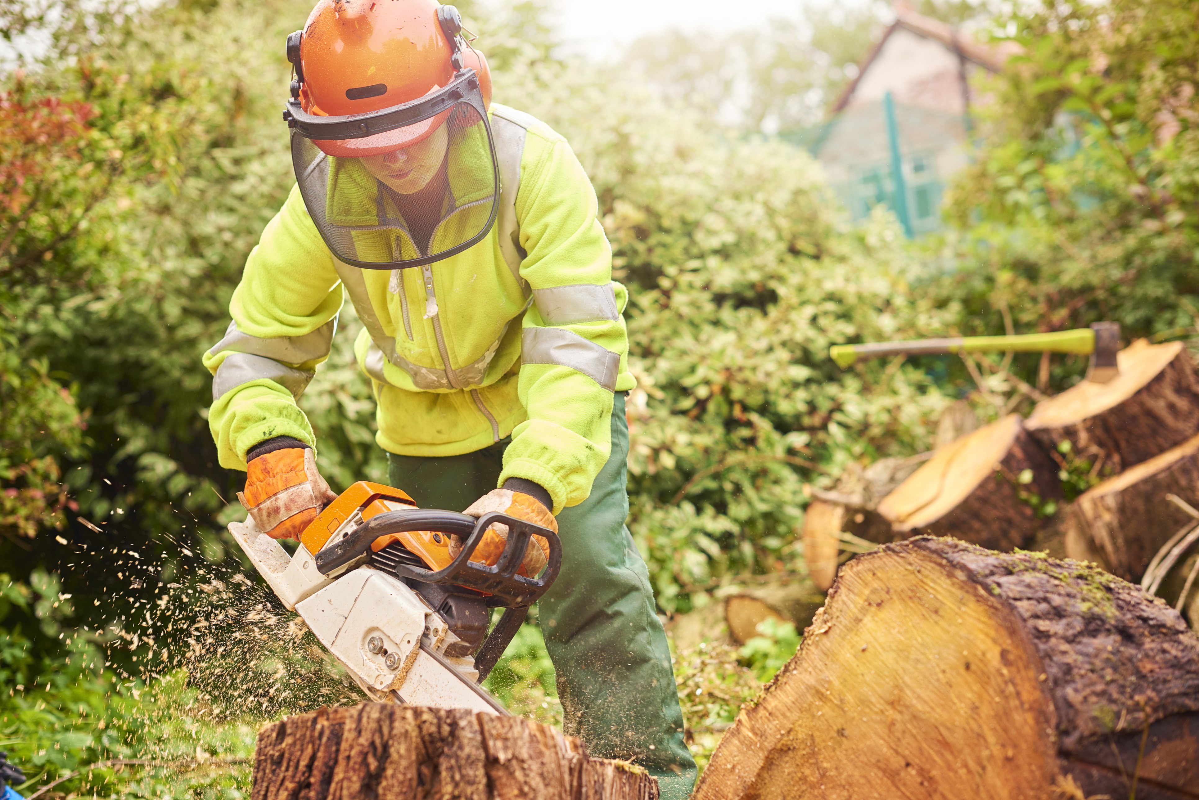 A person using a chainsaw to cut up a log