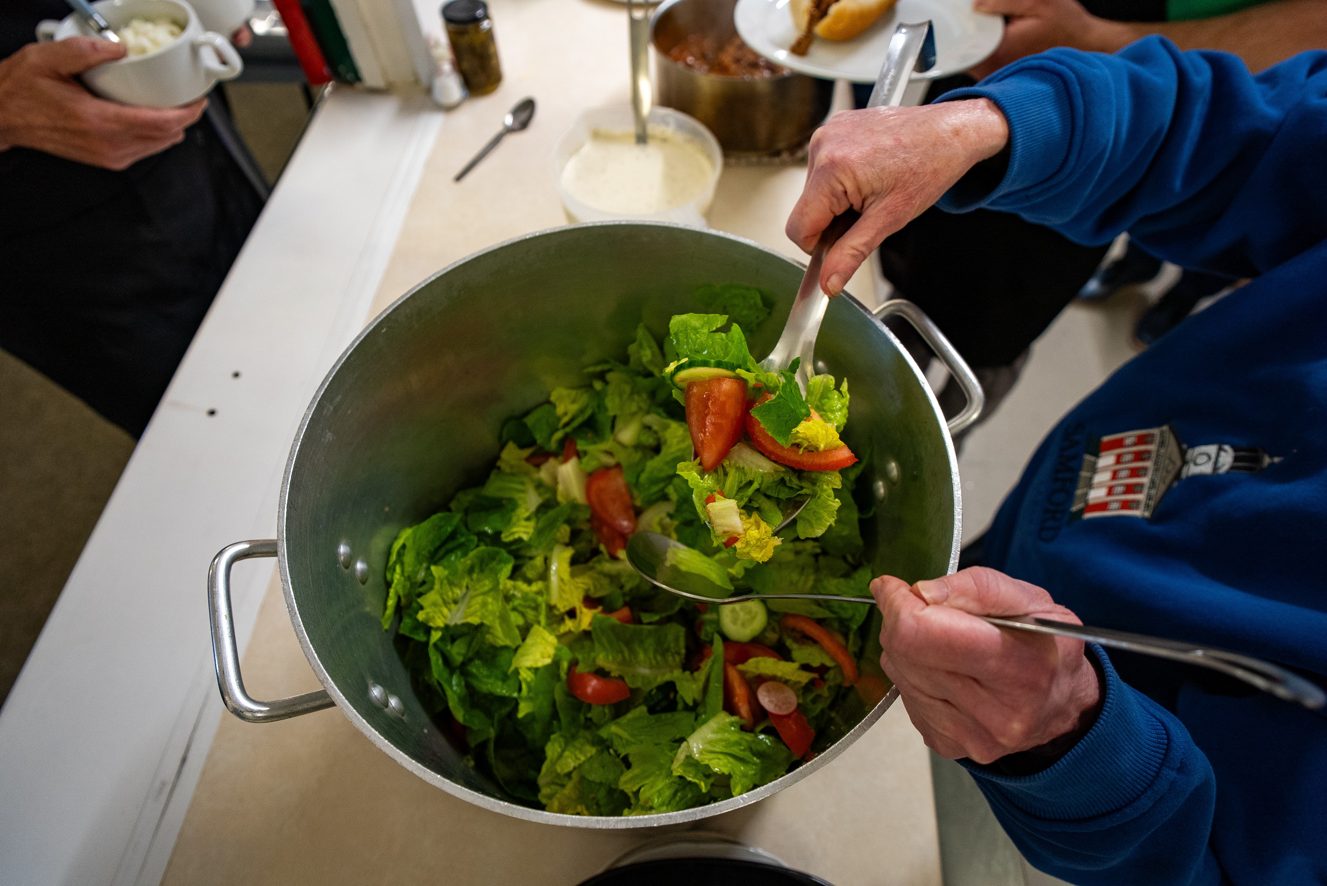 Lady serving salad from a pot