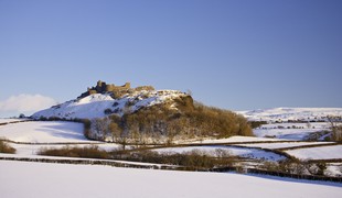 Carreg Cennen Castle on a snow topped hill