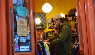 A man looking through a rail of shirts in a second-hand vintage store