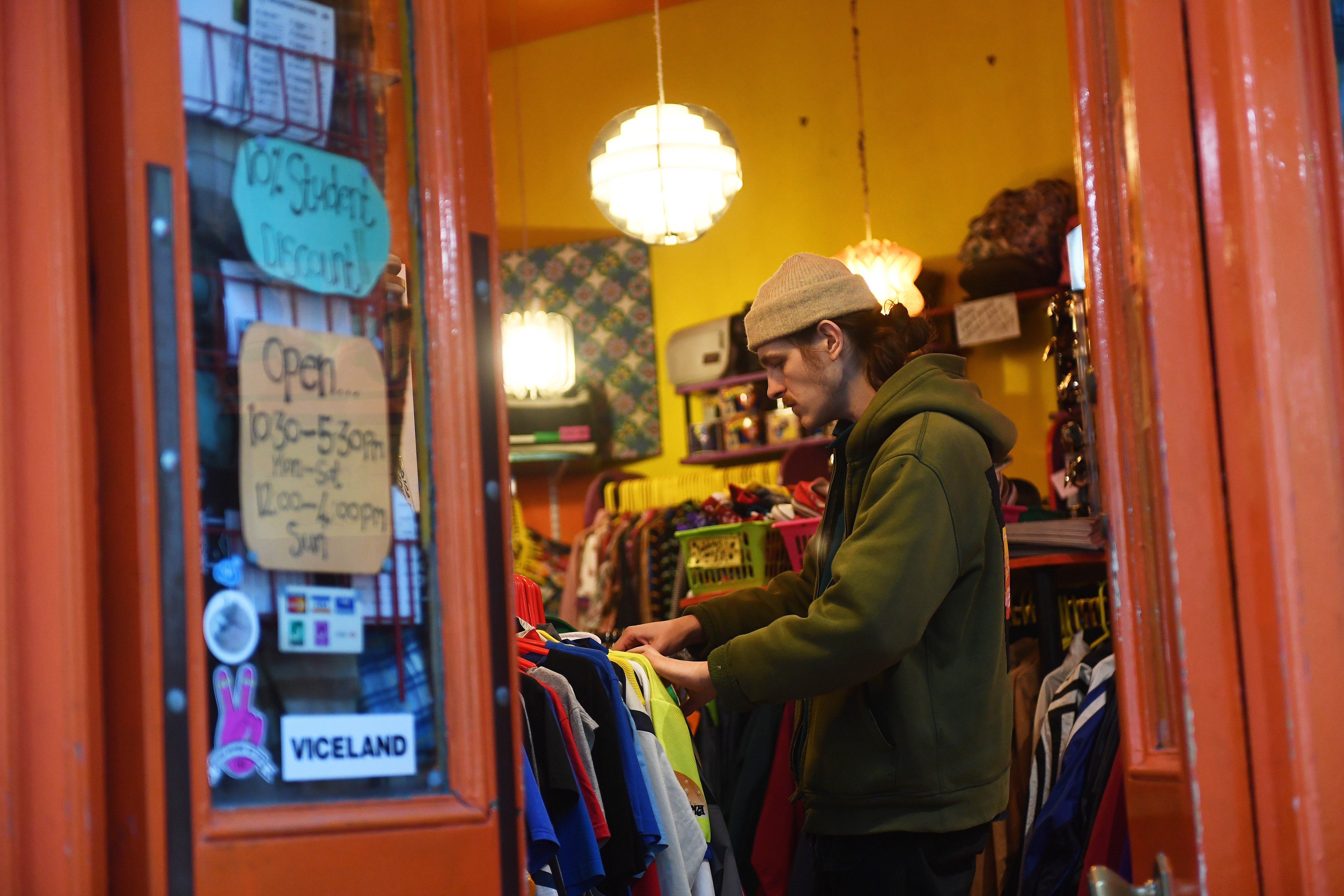 A man looking through a rail of shirts in a second-hand vintage store