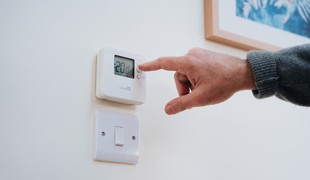The temperature on a thermostat being adjusted from 20 degrees