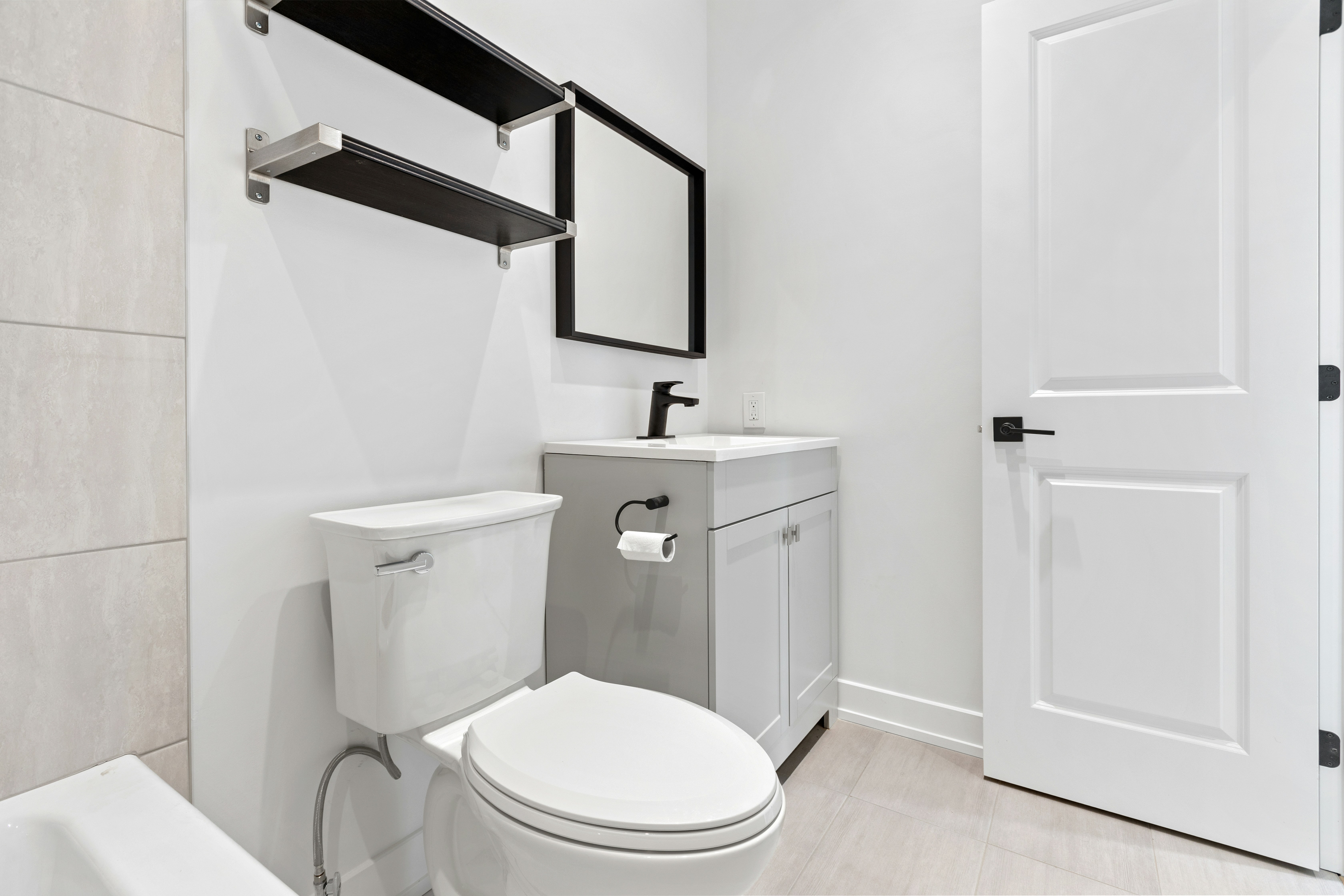 Bathroom with toilet, sink, and mirror