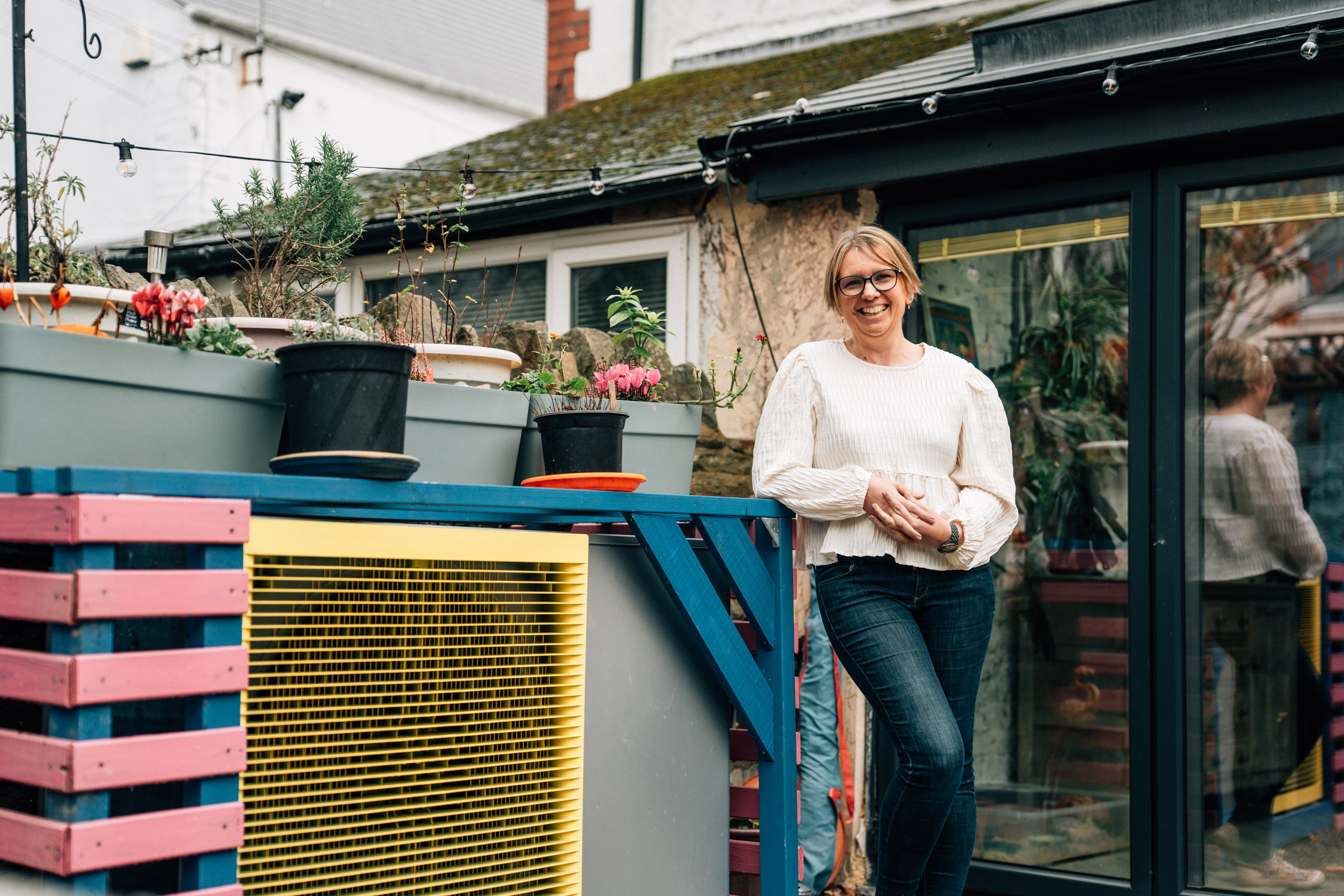 A woman stood next to a heat pump