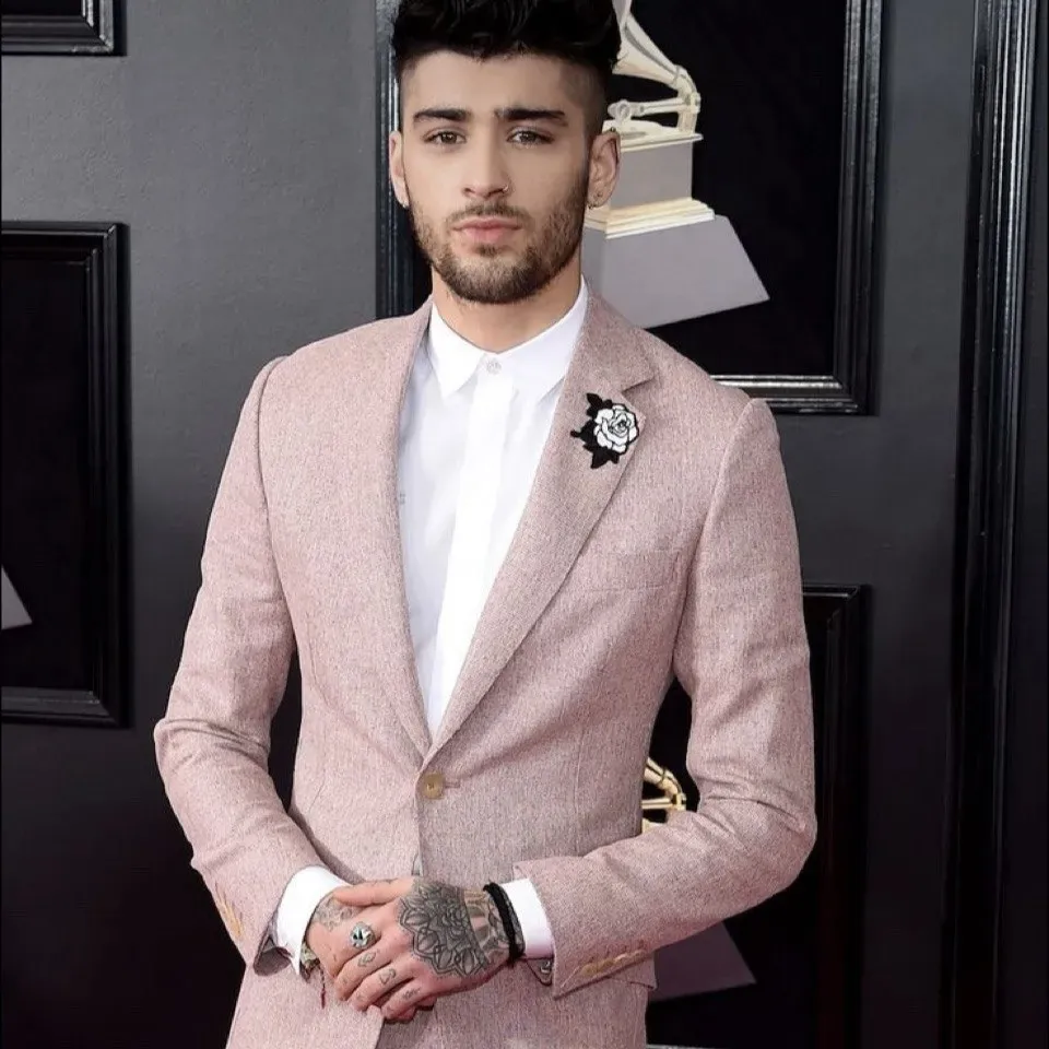 Roze trouwpak met structuur in de stof voor stoere bruidegom met tattoos