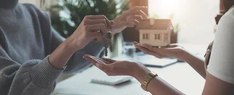 estate-agent-giving-house-keys-woman-sign-agreement-office