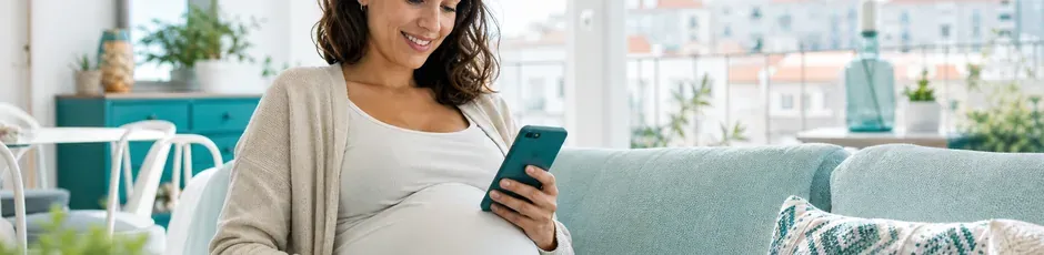 Grávida a consultar o telemóvel, simbolizando o processamento automático do abono de família pré-natal