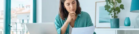 Casal a analisar contrato e prestação do crédito habitação com calculadora e documentos na mesa