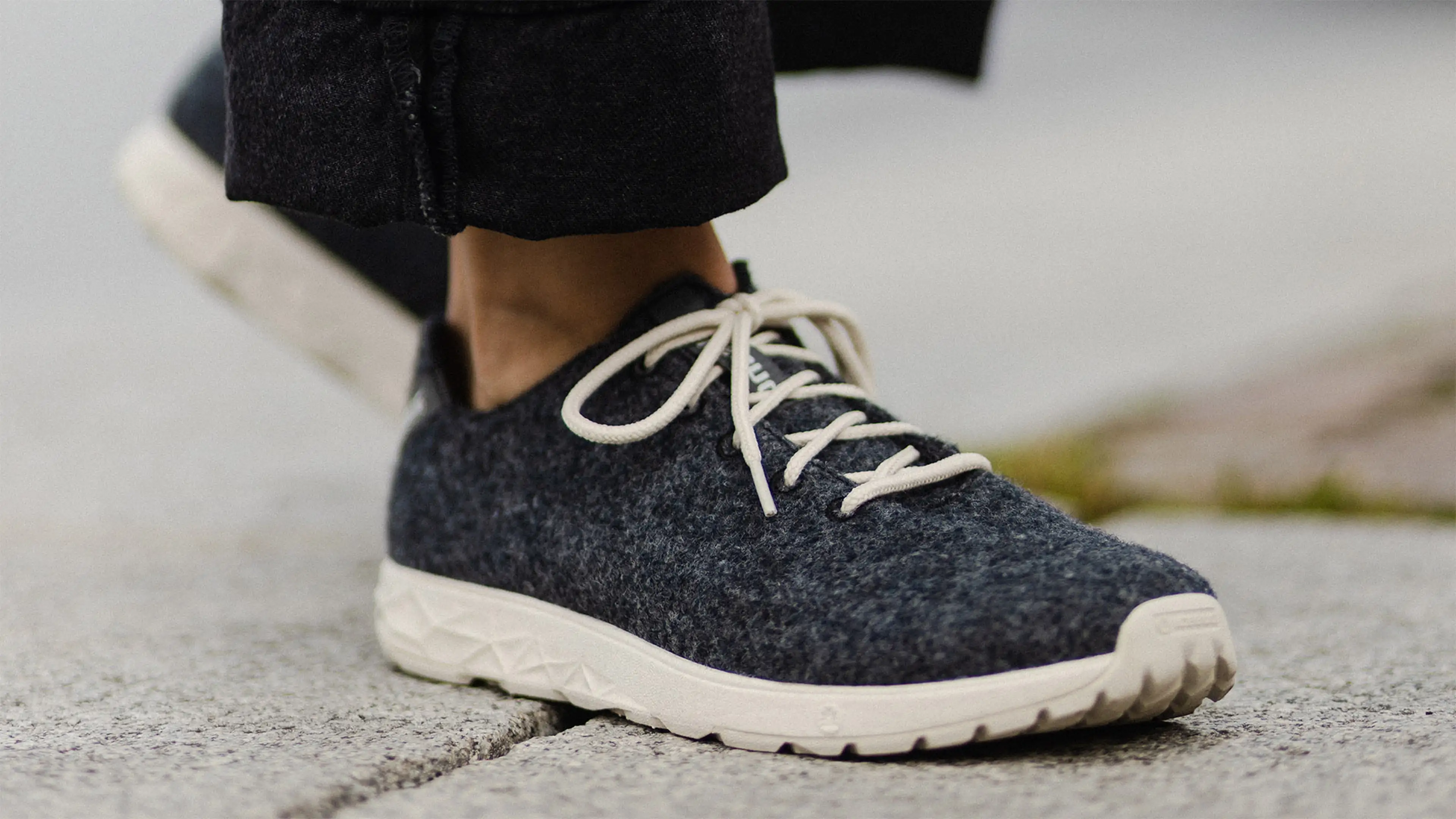 A person in Icebug wool sneakers and black jeans.