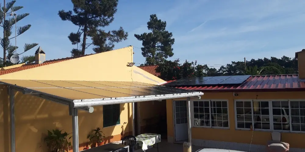 Single-family house in Portugal with guest house, seen from the back with shading and PV panels on the roof.