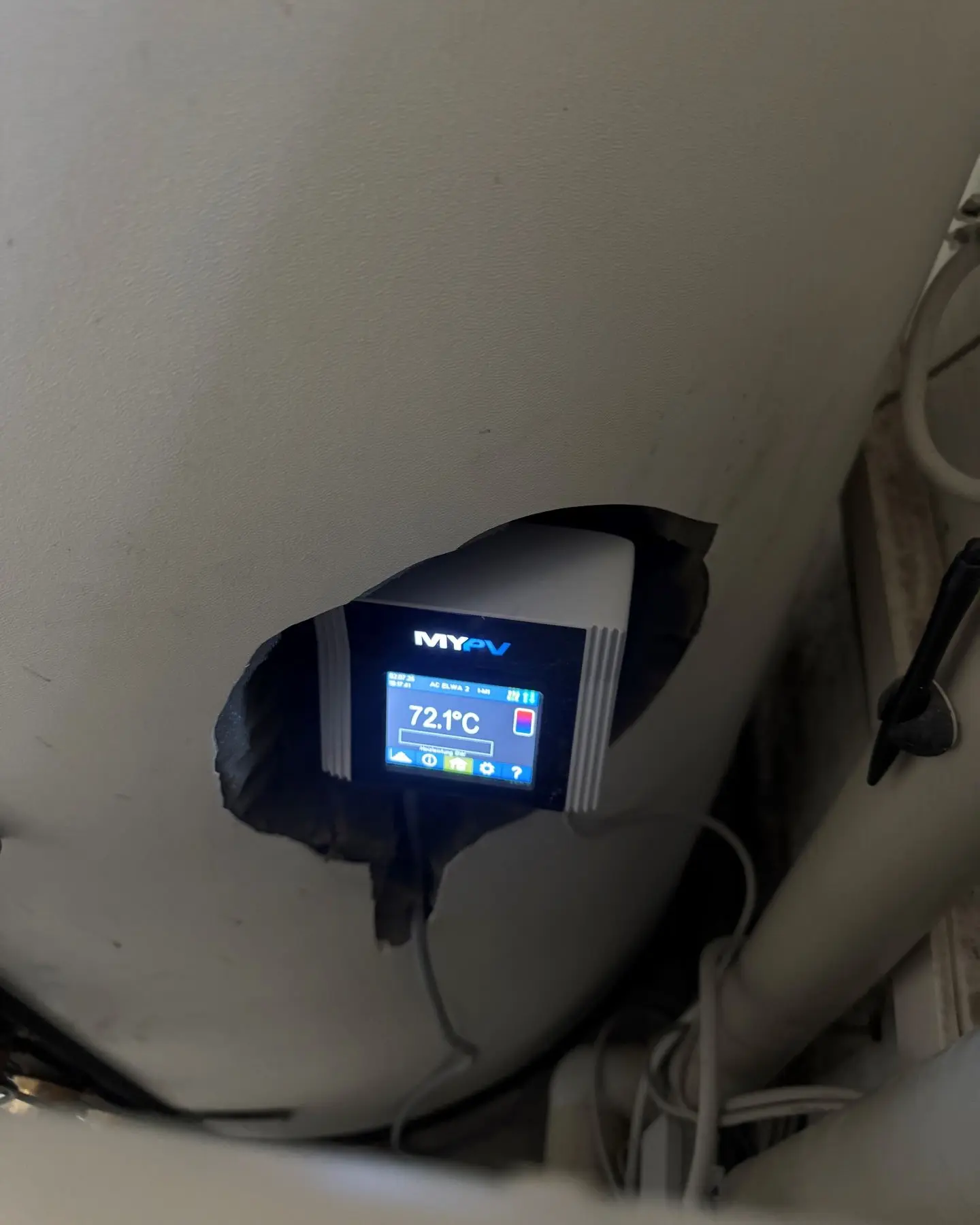 A digital display showing 72.1°C is embedded in a hole on a large cylindrical object, with wires extending from it.