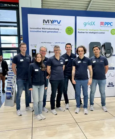 my-PV team in matching navy shirts at Intersolar 2025 in front of a booth with banners for my-PV gridX and PPC