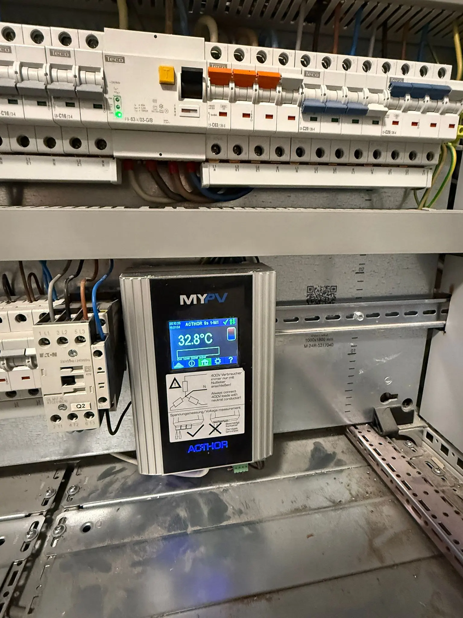 Electrical control panel with various circuit breakers and a digital display showing 32.8°C, labeled "MyPV."