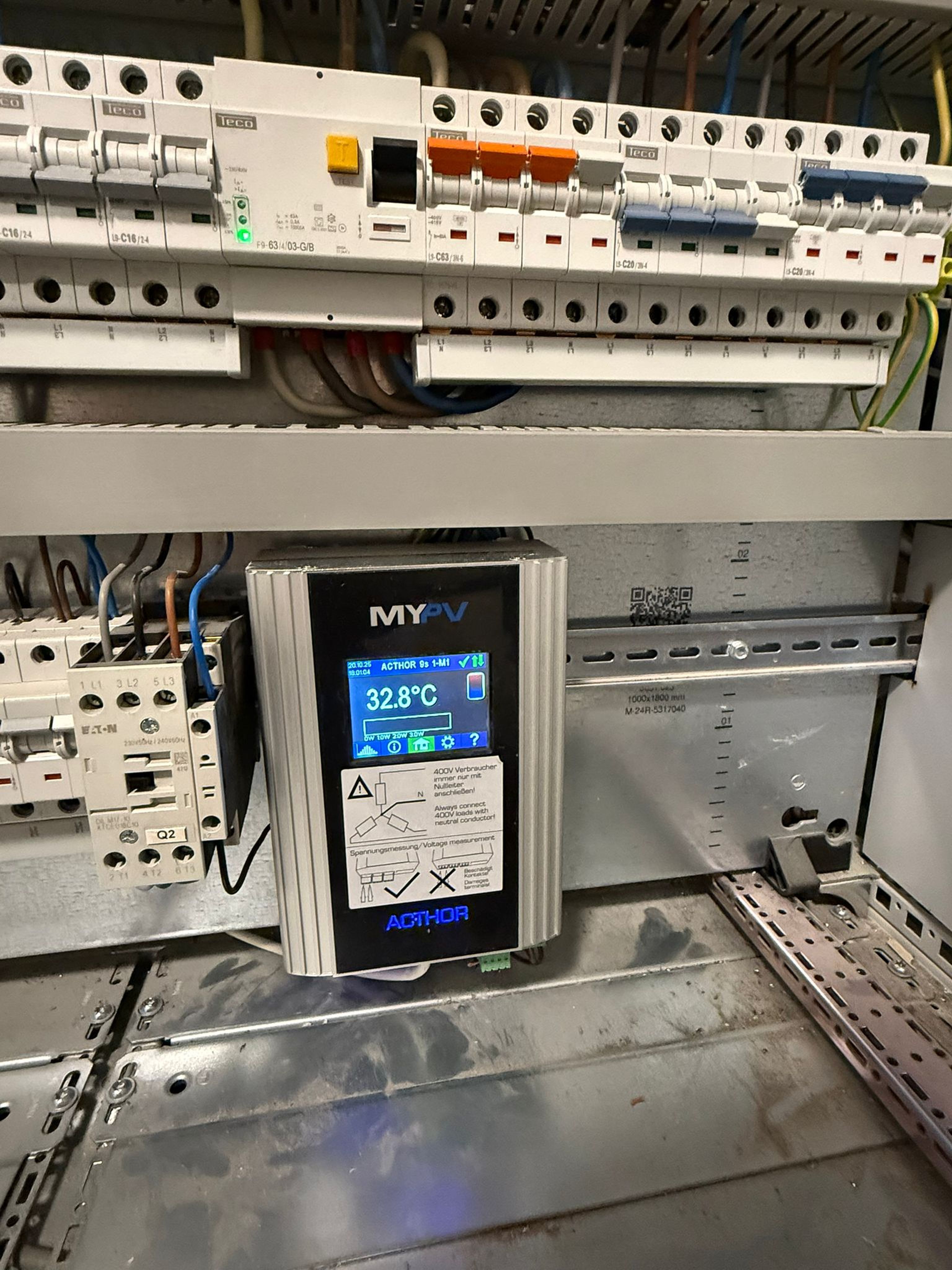 Electrical control panel with various circuit breakers and a digital display showing 32.8°C, labeled "MyPV."