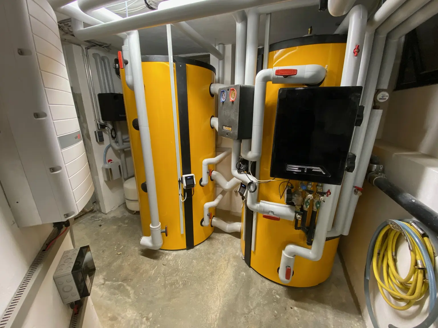 Two yellow water heaters, each equipped with an integrated AC ELWA 2 for solar-electric water heating.