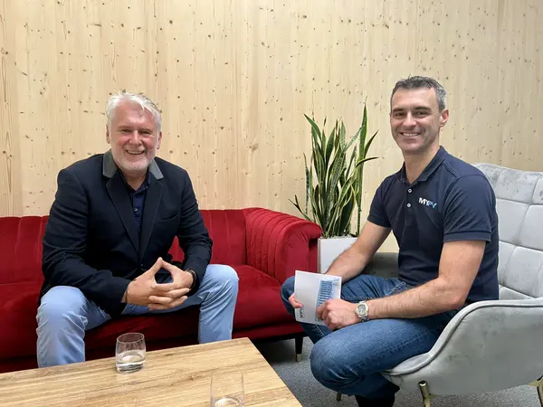 my-PV employee interviews Herbert Bachler on a red couch.