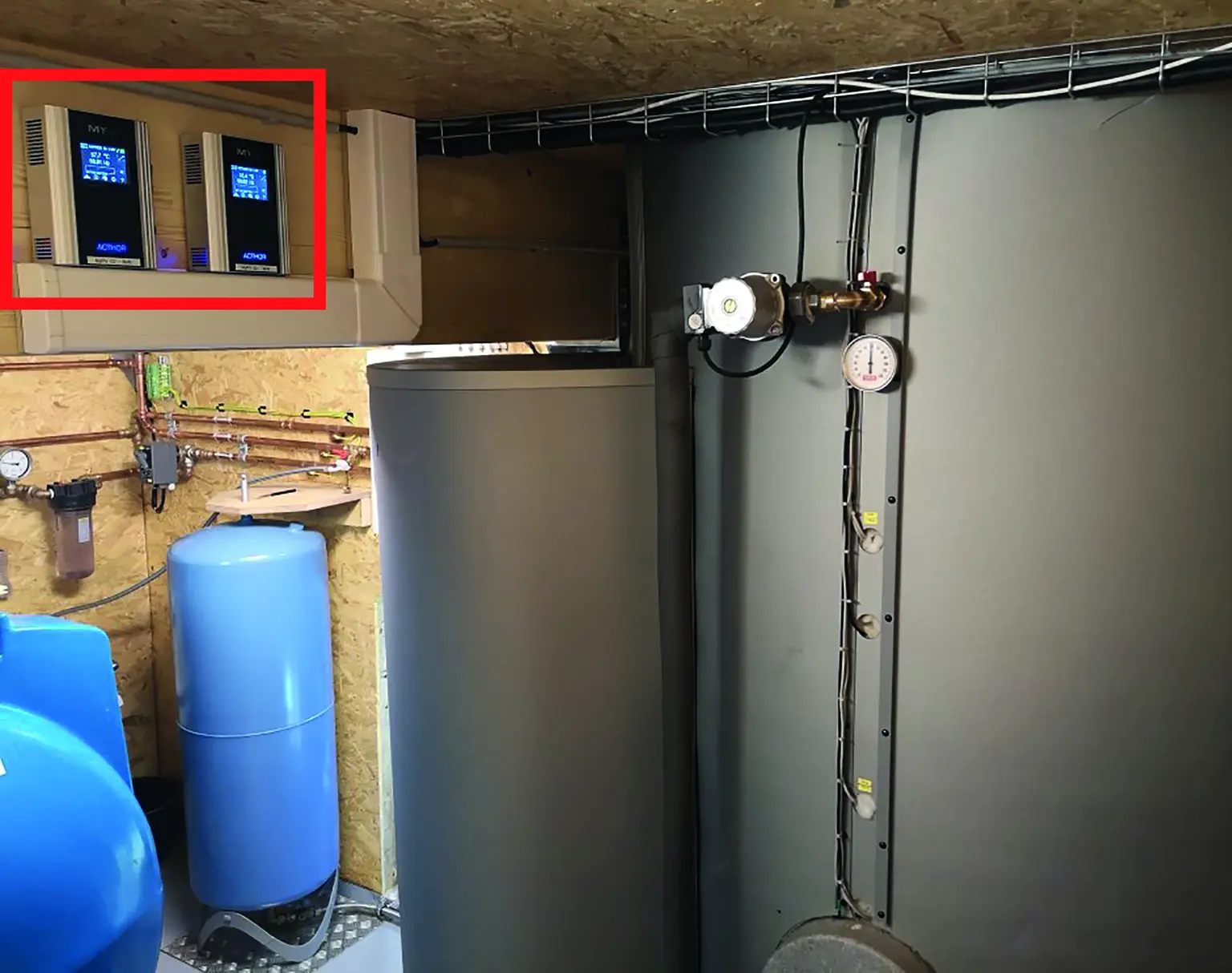 Utility room with large cylindrical tanks, pipes, and gauges; inset shows two mounted AC•THOR units.