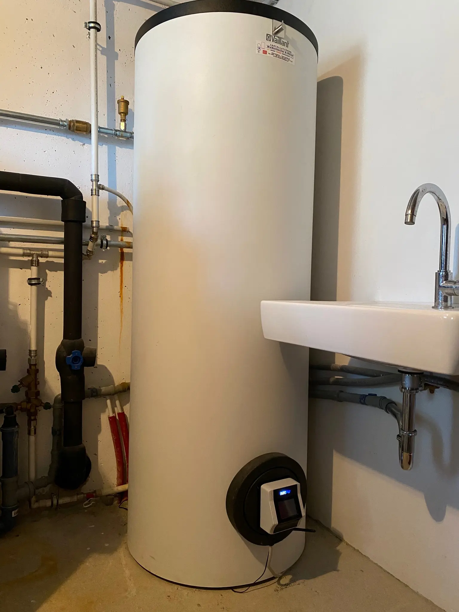 Hot water tank in basement connected to an AC ELWA 2 for water heating.