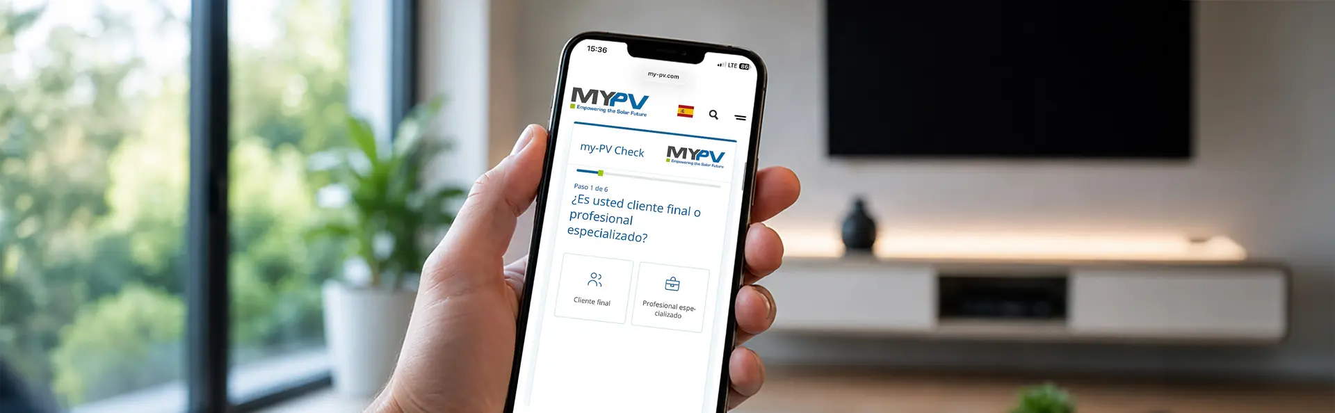 A person is holding a smartphone displaying a website from "MY-PV," with a living room and large window in the background.