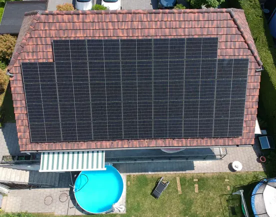 House with 14 kWp PV panels on the roof, a round pool and a trampoline in the garden.
