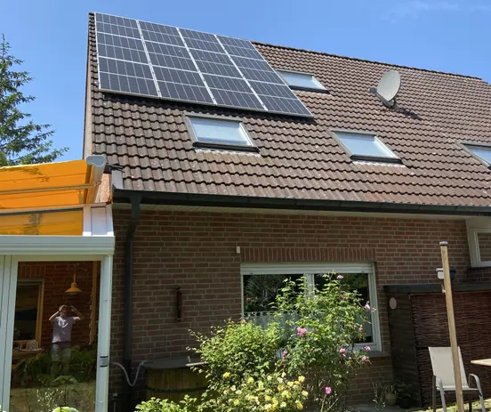 House with a brick facade features photovoltaic panels installed on the roof